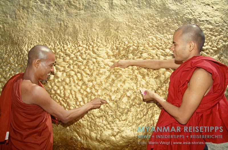 Buddhistische Mönche aus Myanmar spenden Blattgold am Goldenen Felsen Kyaikhtiyo.
