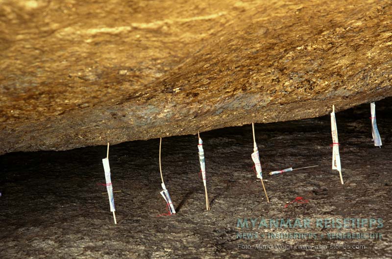 Mit Geldscheinen umwickelte Holzstäbchen sollen den Goldenen Felsen Kyaikhtiyo in seiner Position halten.