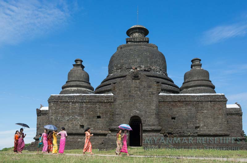 Frauen in Mrauk U auf dem Weg zum Shitthaung-Tempel gehen am Laymyethna-Tempel vorbei.