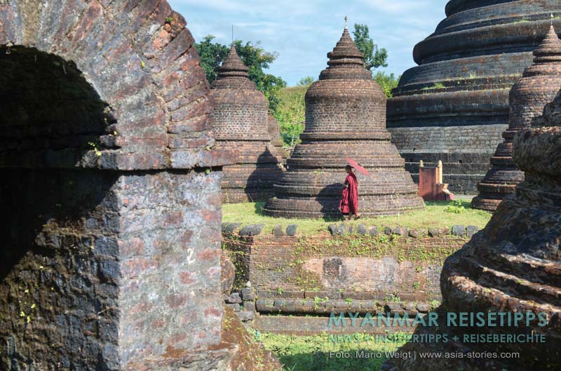 Myanmar Reisetipps | Mrauk U | Mönch mit rotem Bambusschirm am Tempel Ratanabon