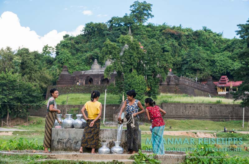 Frauen beim Wasserholen mit den für Mrauk U typischen Aluminiumgefäßen