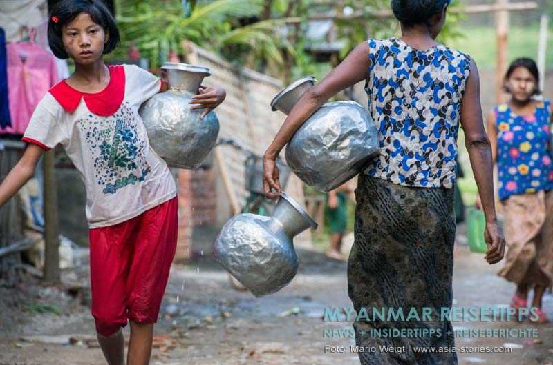 Frauen beim Wasserholen mit den für Mrauk U typischen Aluminiumgefäßen