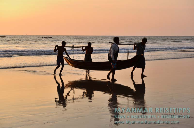 Ngwe Saung Beach (Silberstrand), Fischer tragen ein Beiboot an Land.