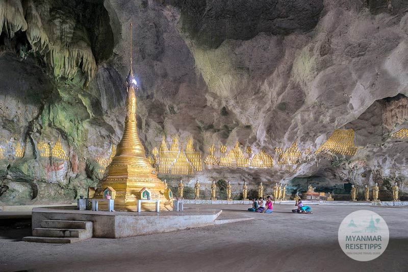 Betende vor der goldenen Stupa und den Wandrelief in der Saddar-Höhle