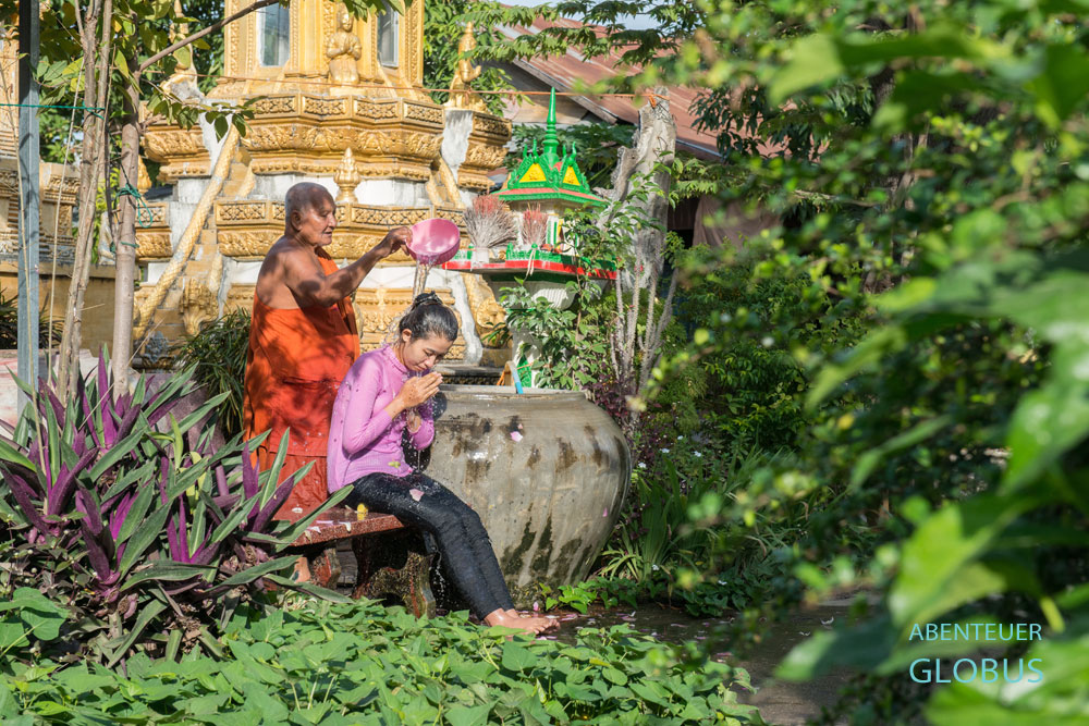 Battambang in Kambodscha: Im Wat Tahm Rai Saw, Kloster des weißen Elefanten, segnet ein buddhistischer Mönch eine Gläubige mit einem Wasserbad.