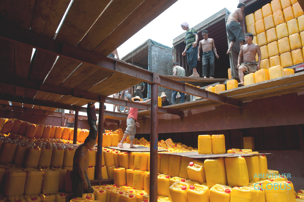 Yunnan am Mekong. Träger entladen ein Cargoboot im Hafen Guan Lei. In den gelben Plastikkanistern befindet sich Speiseöl für Myanmar.
