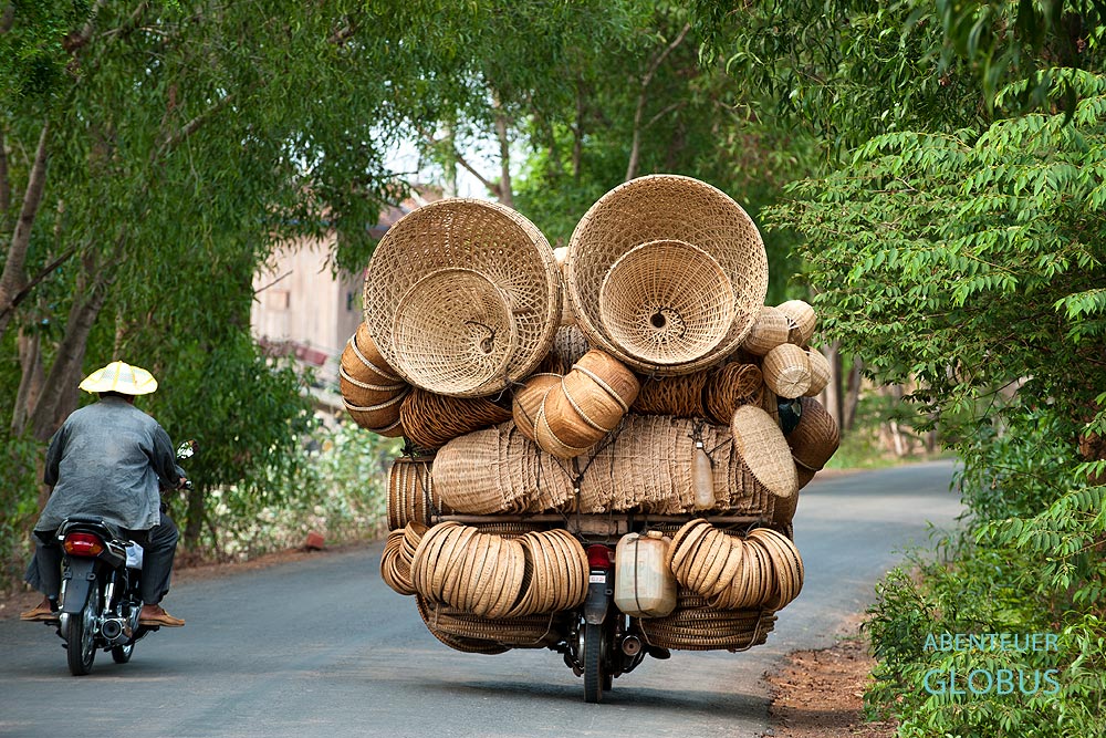 Kratie in Kambodscha:  Ein Korbwarenhändler fährt auf seinem Moped die Dörfer am Mekong ab und bietet seine Ware an.