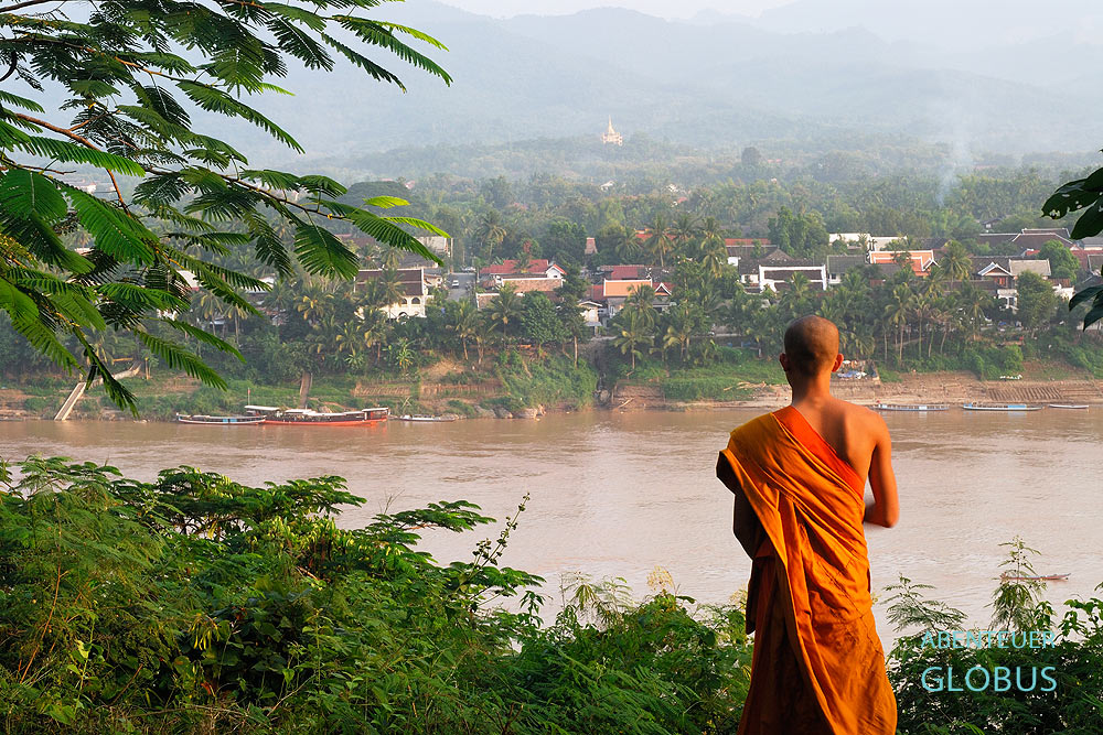 Laos: Ein Mönch schaut vom Wat Chom Phet über den Mekong auf die Stadt Luang Prabang. 