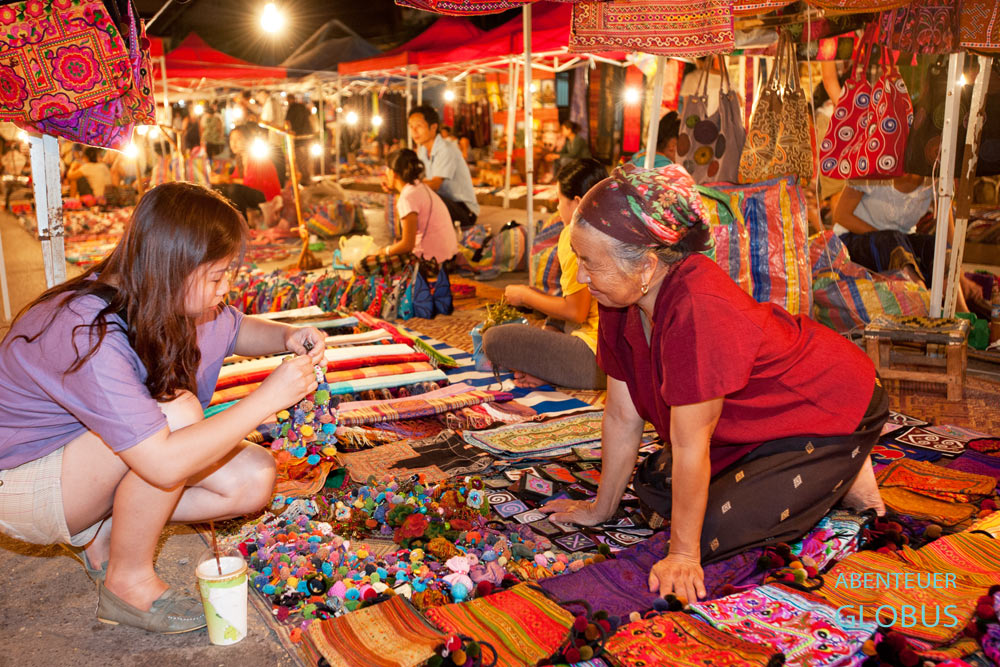 Auf dem Nachtmarkt in der Sisavangvong-Straße in Luang Prabang bieten Händler traditionelle Handarbeit, Buddha-Statuen und vieles mehr an.