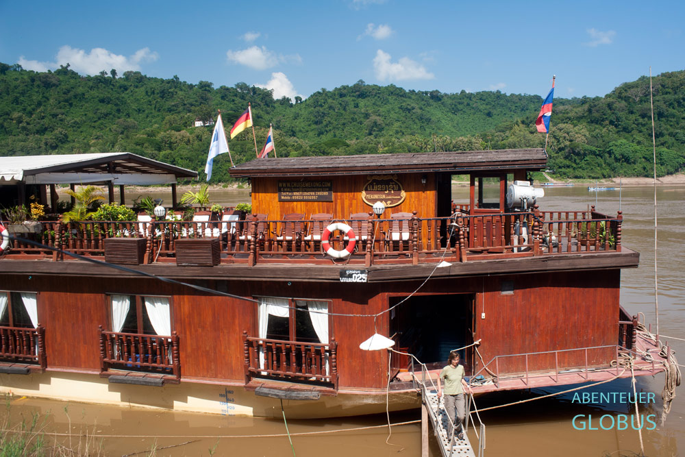 Das Kabinenschiff Mekong Sun vom Reiseunternehmen Lernidee ankert unterhalb vom Wat Xieng Thong in Luang Prabang.