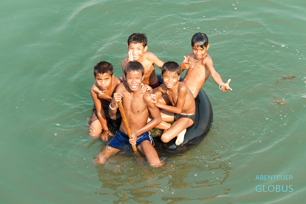 Badespaß im Mekong in Laos. Ein Schlauch von einem Traktor dient als schwimmender Untersatz für die Kids. Weiter südlich auf der Backpacker-Insel Don Det nennt man es Tubing.