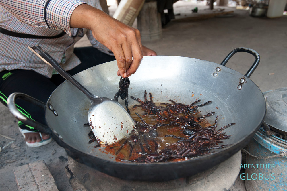 Kambodschanische Frauen im Ort Skoun würzen, braten und frittieren Vogelspinnen in Öl bis Beine und Körper knusprig sind.