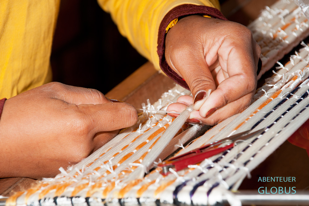 Seidenmanufaktur Mekong Blue in Stung Treng. Bei der Ikat-Technik spannt die Weberin die Seidenfäden auf einen Rahmen und bindet diese nach entsprechenden Muster eng zusammen.
