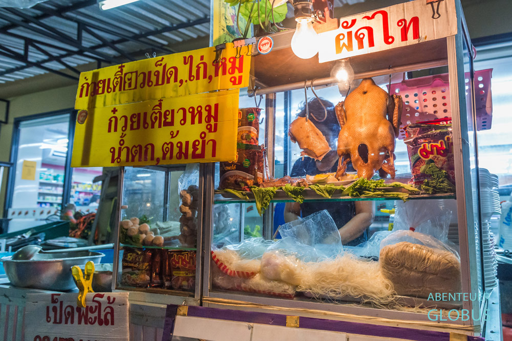 Thailand, Bangkok. In den Garküchen am Straßenrand gibt es authentisches Thai Food. Die Verkäuferin serviert Nudelsuppen mit Huhn oder Ente.