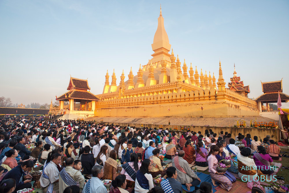 Am Morgen versammeln sich die Laoten um den goldenen Stupa des That-Luang-Tempels in Vientiane, um gemeinsam mit den Mönchen zu beten.