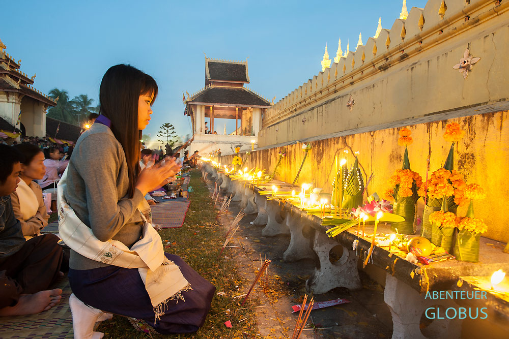 Zu den Andachten und Gesängen der buddhistischen Mönche beten die Gläubigen am That-Luang-Tempel am Morgen.