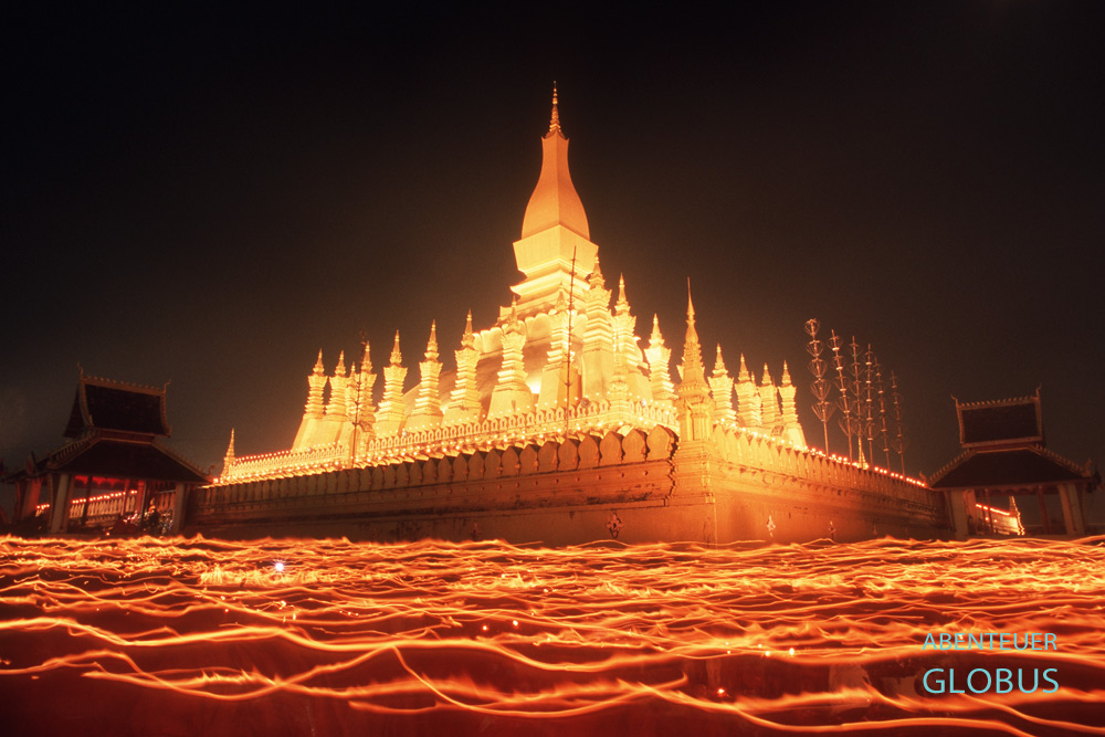 Am Abend des Vollmontages umrunden Mönche und Gläubige mit Kerzen den goldenen Stupa zum That Luang Festival in Vientiane.