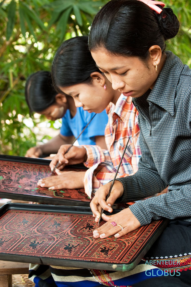 Frauen gravieren kunstvolle Ornamente in die mehrfarbige Lackschicht im Baganer Ever Stand Lacquerware Workshop in Myanmar.