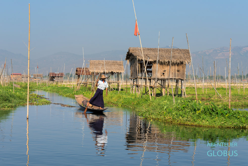 Mit der einzigartigen Einbeinrudertechnik gleitet ein Fischer durch die schwimmenden Gärten auf dem Inle-See in Myanmar.