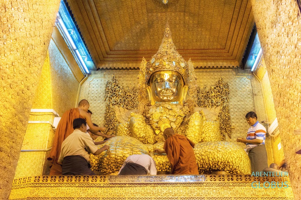 Buddhisten spenden Goldplättchen am Mahamuni-Buddha in Mandalay in Myanmar.