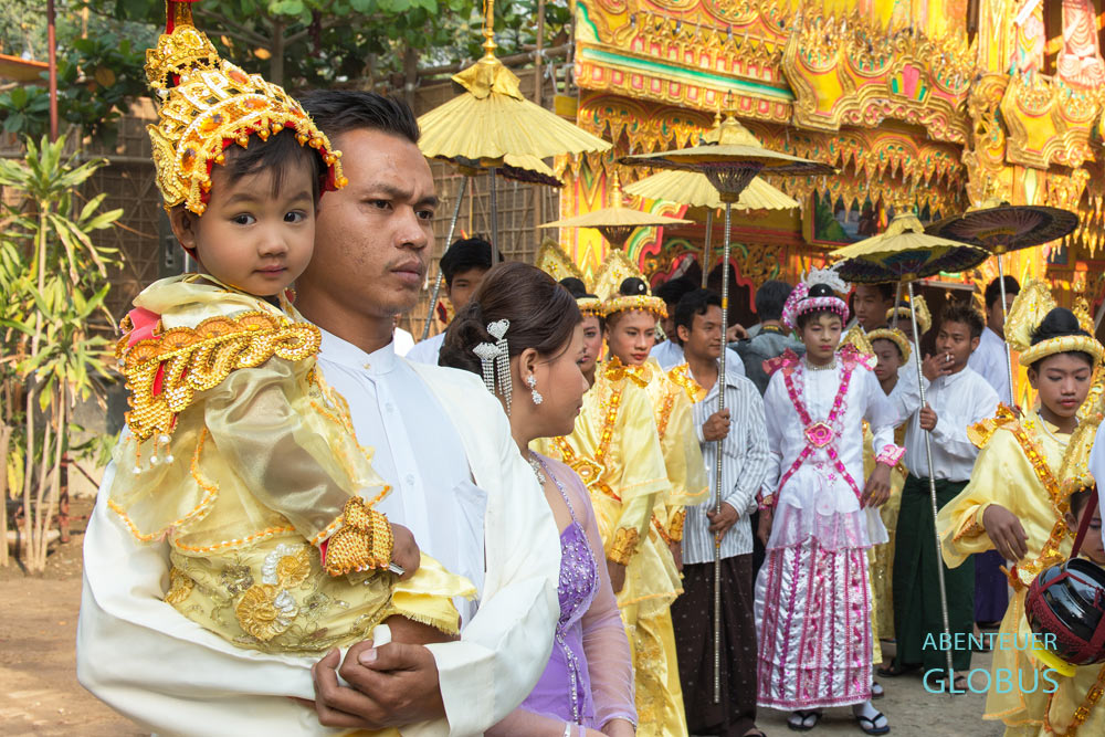 Vor dem Gang zum Dorfkloster nahe Mandalay sammelt sich die Gesellschaft zum Festumzug für die Novizenweihe Shin Pyu.