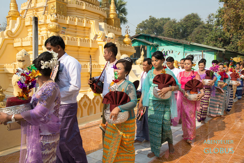 Zur Novizenweihe Shin Pyu nahe Mandalay umrundet die feierliche Prozession den Dorftempel.