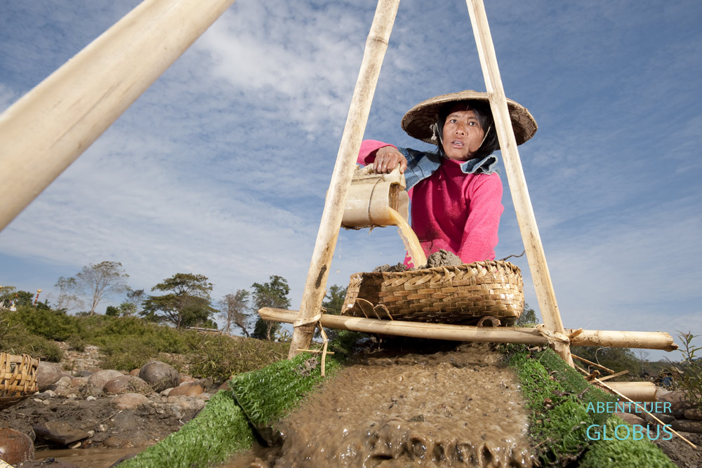 Im Ayeyarwady kippt eine Goldsucherin Flusssand auf die Holzrutsche und hofft, dass winzige Goldpartikel hängenbleiben.