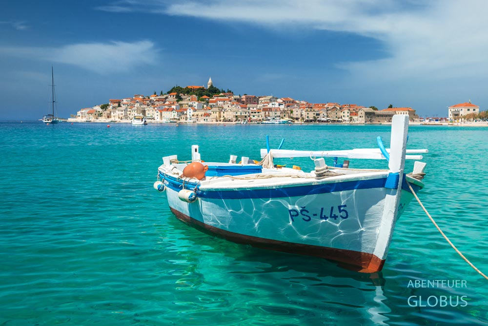 Fischerboot vor der Halbinsel mit Altstadt Primosten in Kroatien