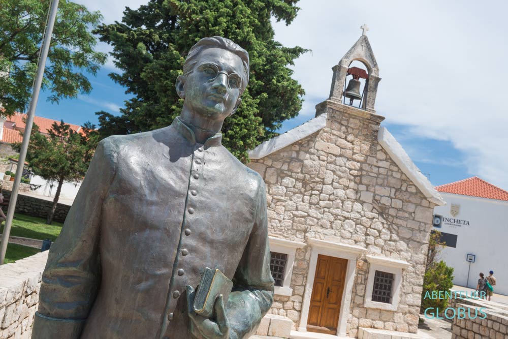 Statue von Don Ivo Saric an der Kirche des Heiligen Roch (Sveti Rok) in Primosten 