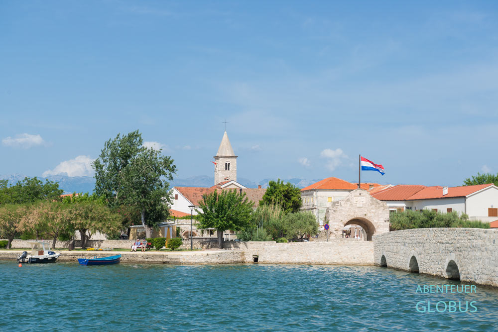 Altstadt Nin auf einer Halbinsel in Dalmatien: Untere Stadtbrücke, Unteres Stadttor und Glockenturm der Kirche Hl. Anselm