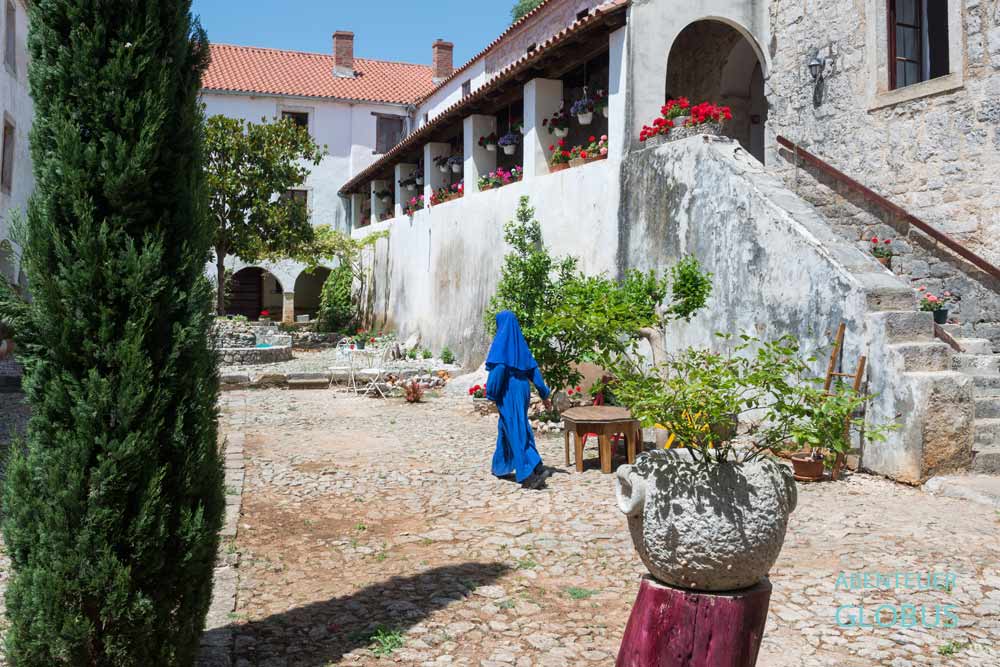 Naturpark Velebit in Kroatien nahe Zrmanja-Schlucht: Eine Nonne im Innenhof vom Kloster Krupa im Dorf Krupa.