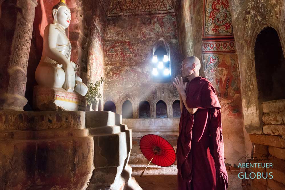 Mönch im Kloster beim Gebet: Fotoserie Der Rote Schirm aus Südostasien, Fotograf Mario Weigt