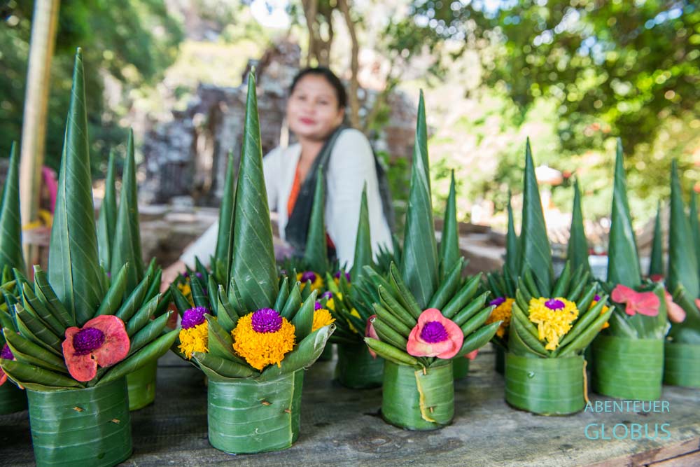 Wat Phou in Laos: Eine Laotin verkauft Blumengebinde zum Spenden.