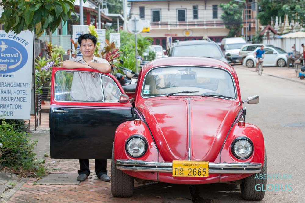 Tipps für Vientiane in Laos: Dieser Oldtimerbesitzer ist stolz auf seinen roten VW Käfer.