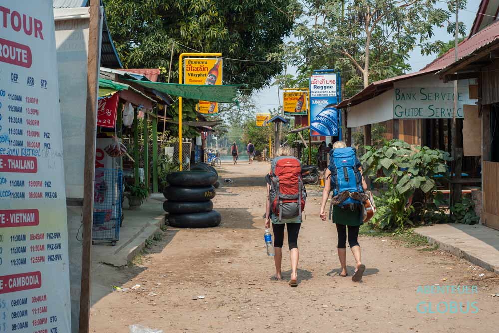 Backpacker mit Rucksäcken laufen auf der Insel Don Det zur Fähre, Laos.