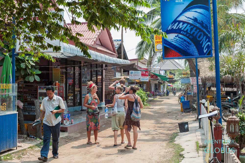 Backpacker unterhalten sich auf der Dorfstraße der Insel Don Det, Laos.