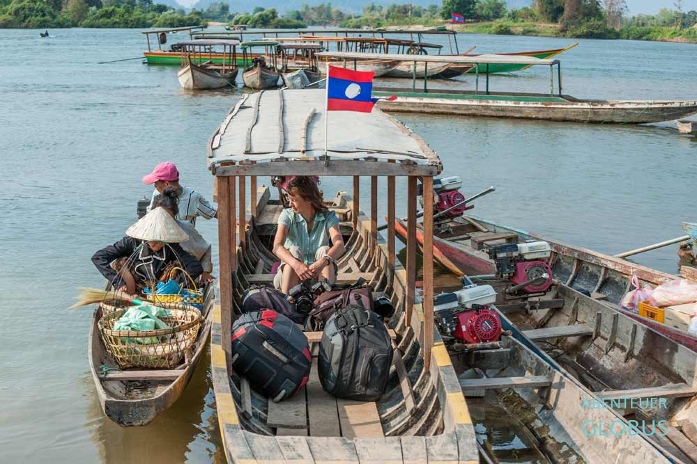 Touristin mit Koffern auf einem kleinen Fährboot zur Insel Don Det, Laos.