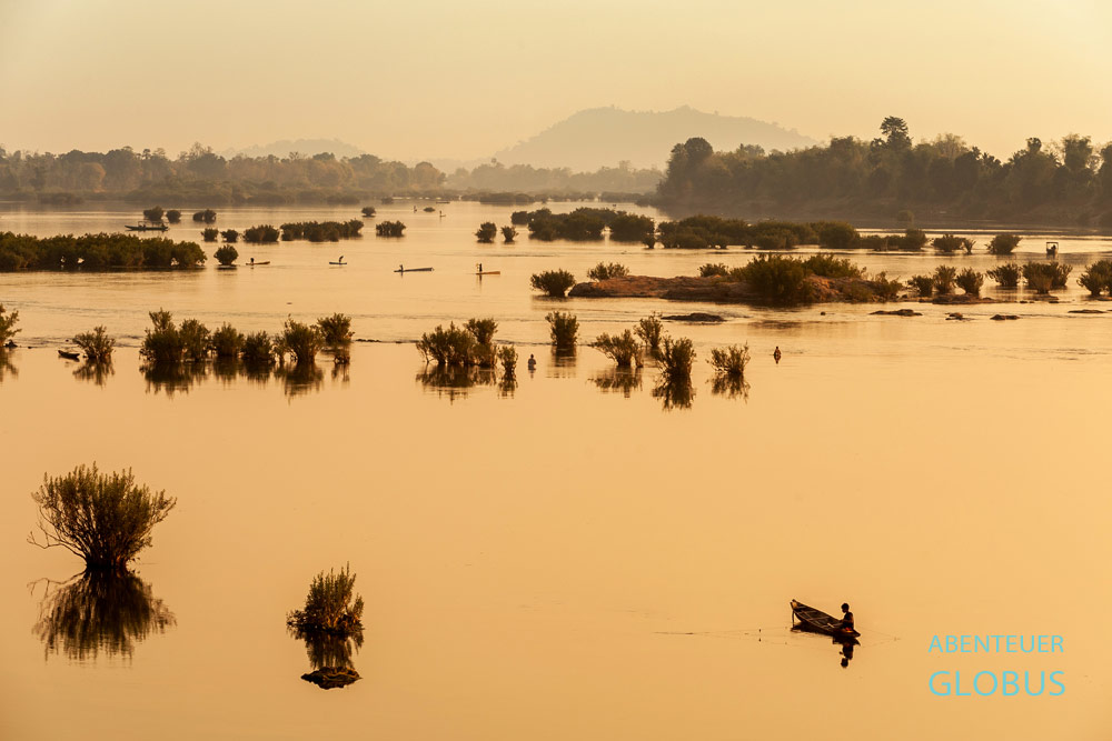 Blick auf Fischer vor der Insel Don Khong, die im Sonnenuntergang zwischen kleinen Inseln fischen.