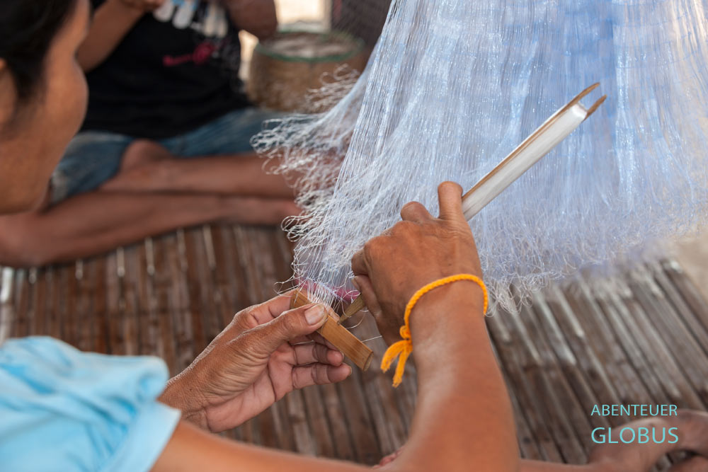 Frau repariert ein Fischernetzt auf der Insel Don Som.
