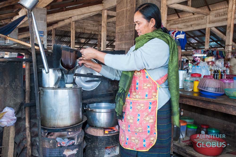 Tipps für Paksong und das Bolaven-Plateau: Laotin brüht frischen Kaffee Lao an einem Marktstand auf.