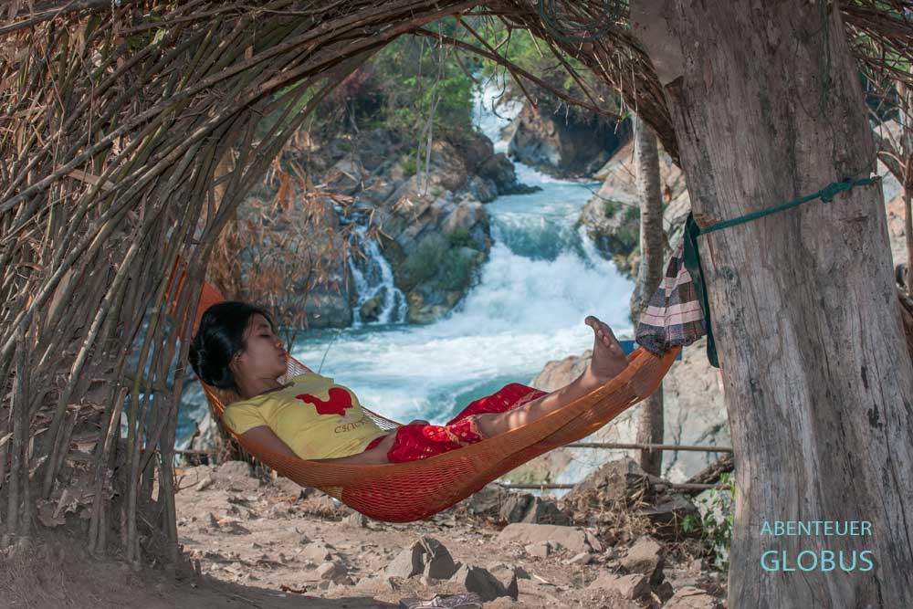 Frau liegt in einer Hängematte am Wasserfall Somphamit und schläft.