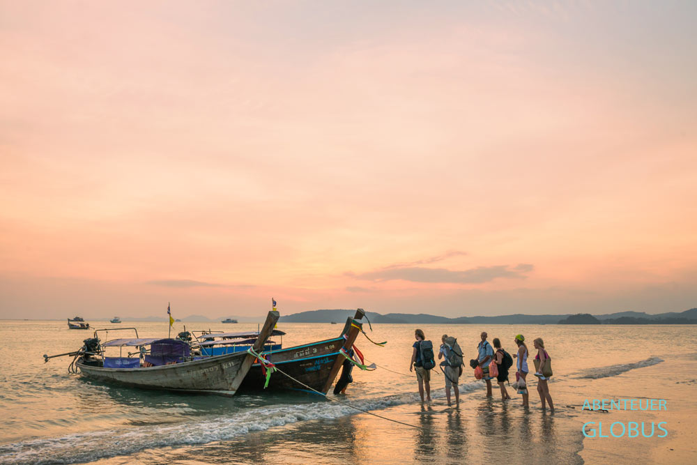 Touristen warten in Ao Nang auf das Longtailboot zum Railay Beach.