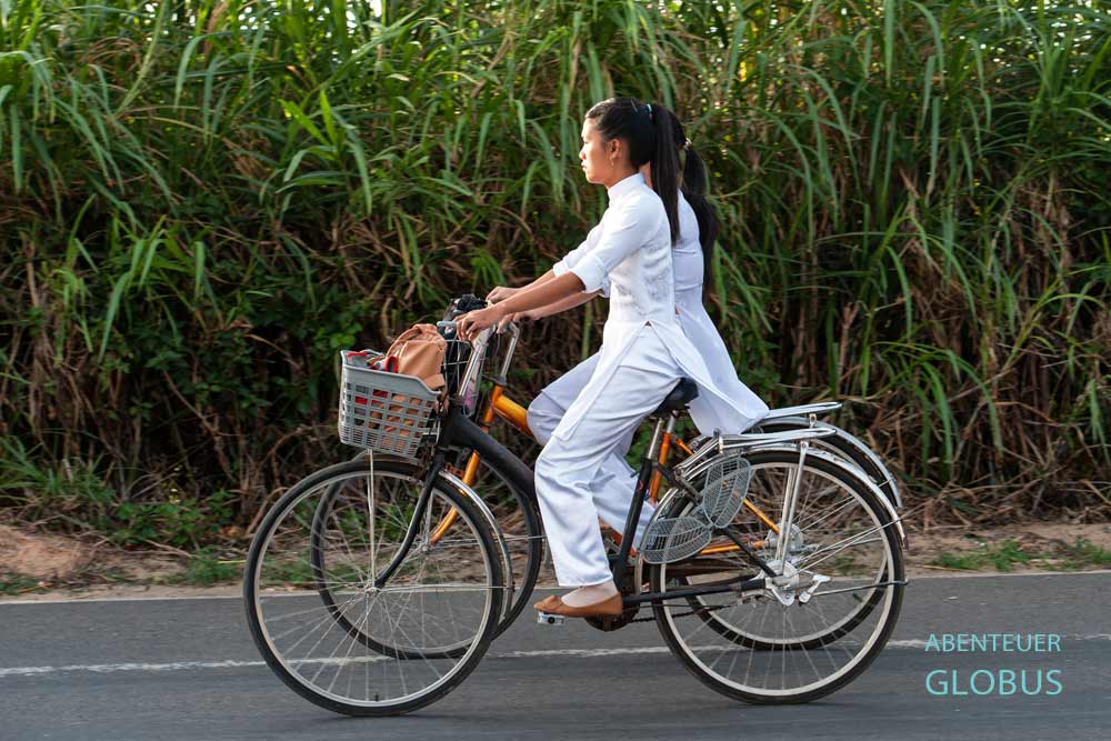 Schülerinnen im traditionellen Ao Dai Kleid auf dem Rad