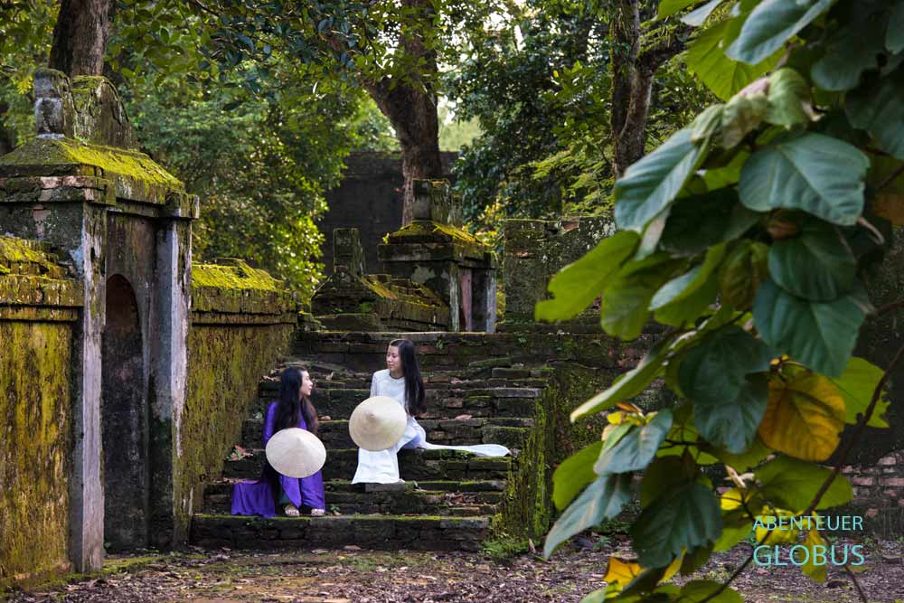 Sehenswürdigkeit bei Hue: Kaisergrab Tu Duc mit Frauen im Ao Dai Gewand