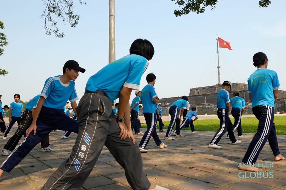 Schüler beim Morgensport am Flaggenturm der königlichen Zitadelle in Hue