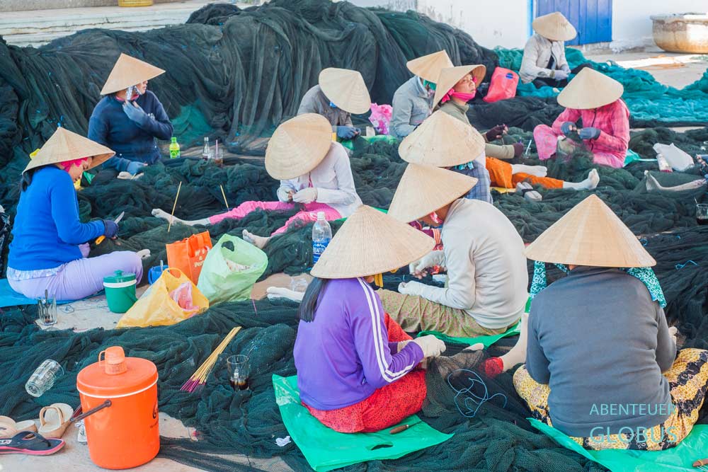 Vietnamesinnen reparieren die Fangnetze in Duong Dong.