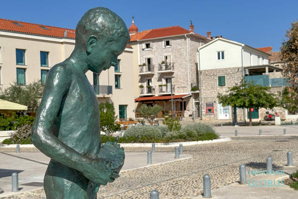 Betina, Insel Murter: Denkmal Junge mit Gajeta Boot am Hauptplatz Trg Betina