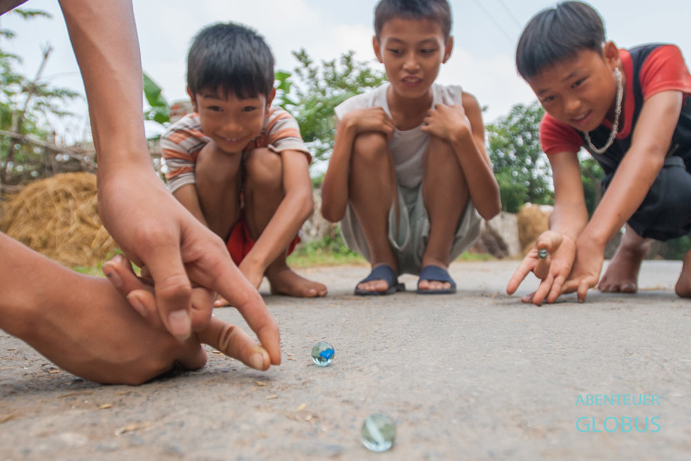 Jungen beim Glasmurmelspiel in Ninh Binh