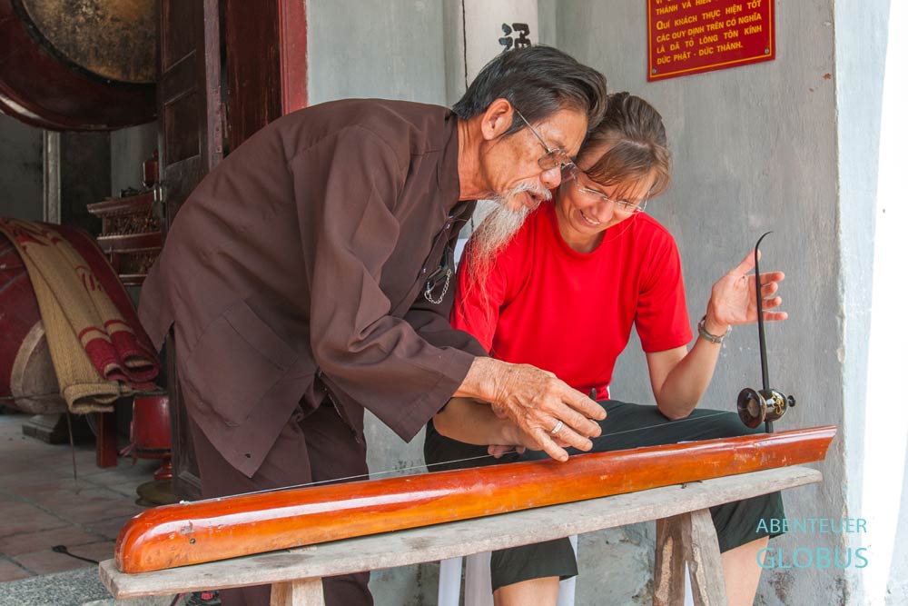 Ninh Binh: Priester mit Zither Dan bau im Thai Vi Tempel