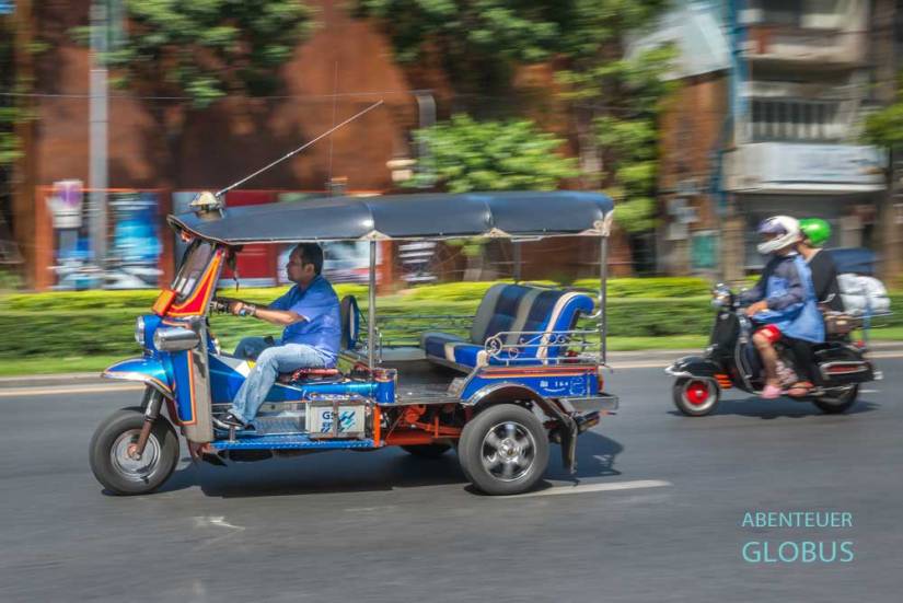 Blaues Tuk-Tuk ohne Fahrgäste im Verkehr von Bangkok